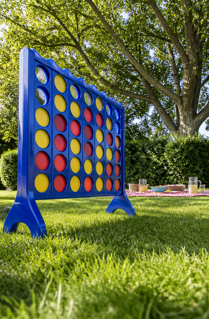 Oversized Connect 4 game set up in a backyard.