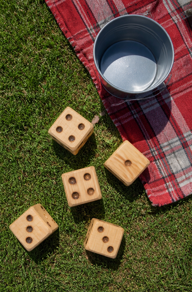 Large wooden lawn dice cut from lumber on grass.