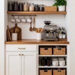 A built-in coffee station with wooden shelves, white tile, and an espresso machine.